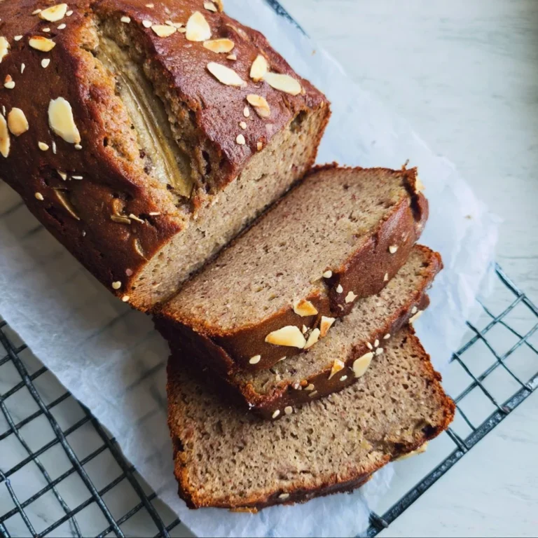 Sliced buckwheat banana bread with ripe bananas and walnuts on a wooden board.