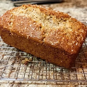 Loaf of homemade Coconut Banana Bread with sliced bananas on top