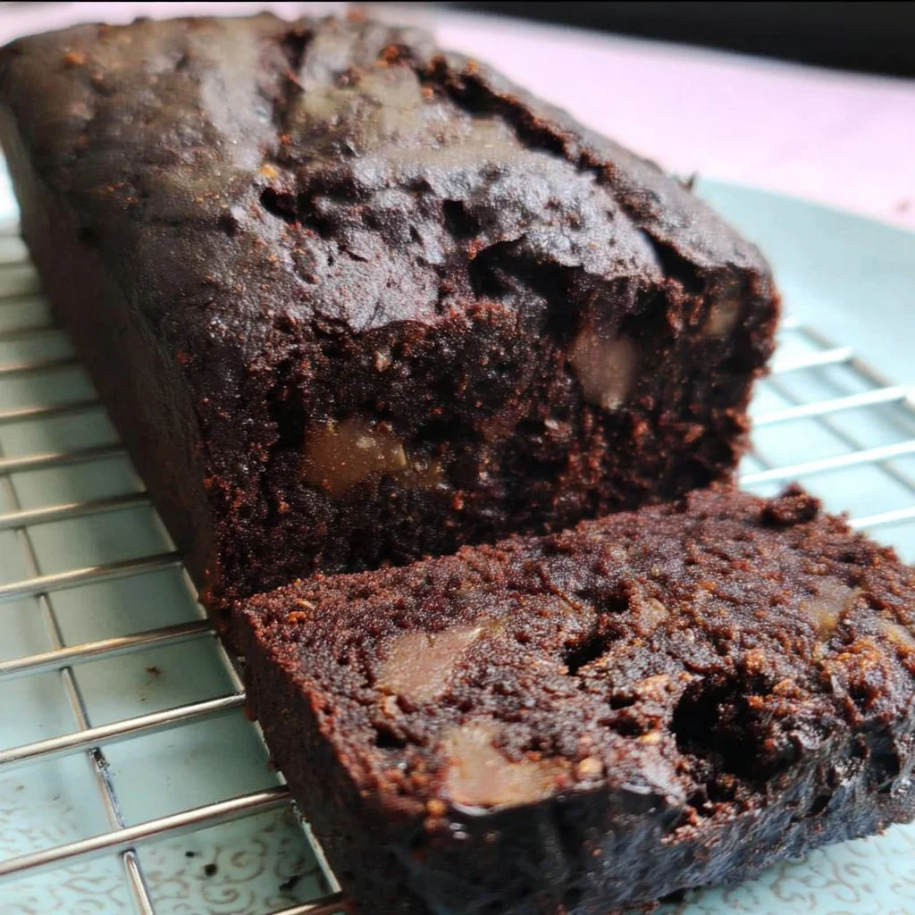A slice of vegan double chocolate banana bread garnished with chocolate chips