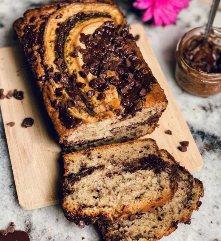 Vegan Banana Bread with Chocolate Hazelnut Swirl on a wooden cutting board.