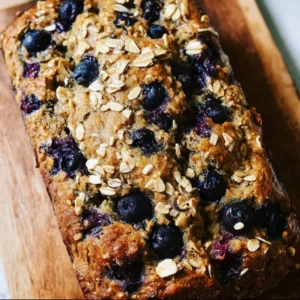 Vegan blueberry banana oat bread fresh out of the oven, sliced and ready to serve.