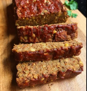 Delicious Vegan Barbecue Lentil Loaf served with barbecue sauce on a plate.